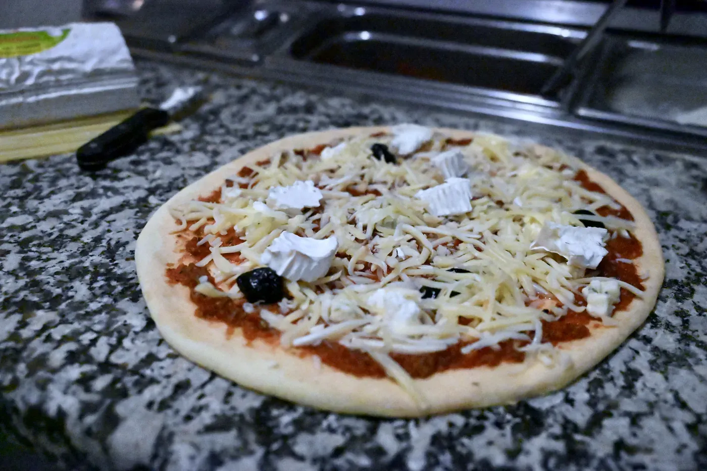 Pizza garnie avant cuisson au feu de bois