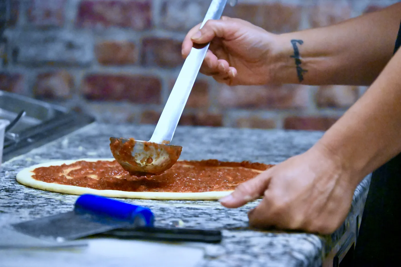 Sauce tomate étalée sur la pâte à pizza